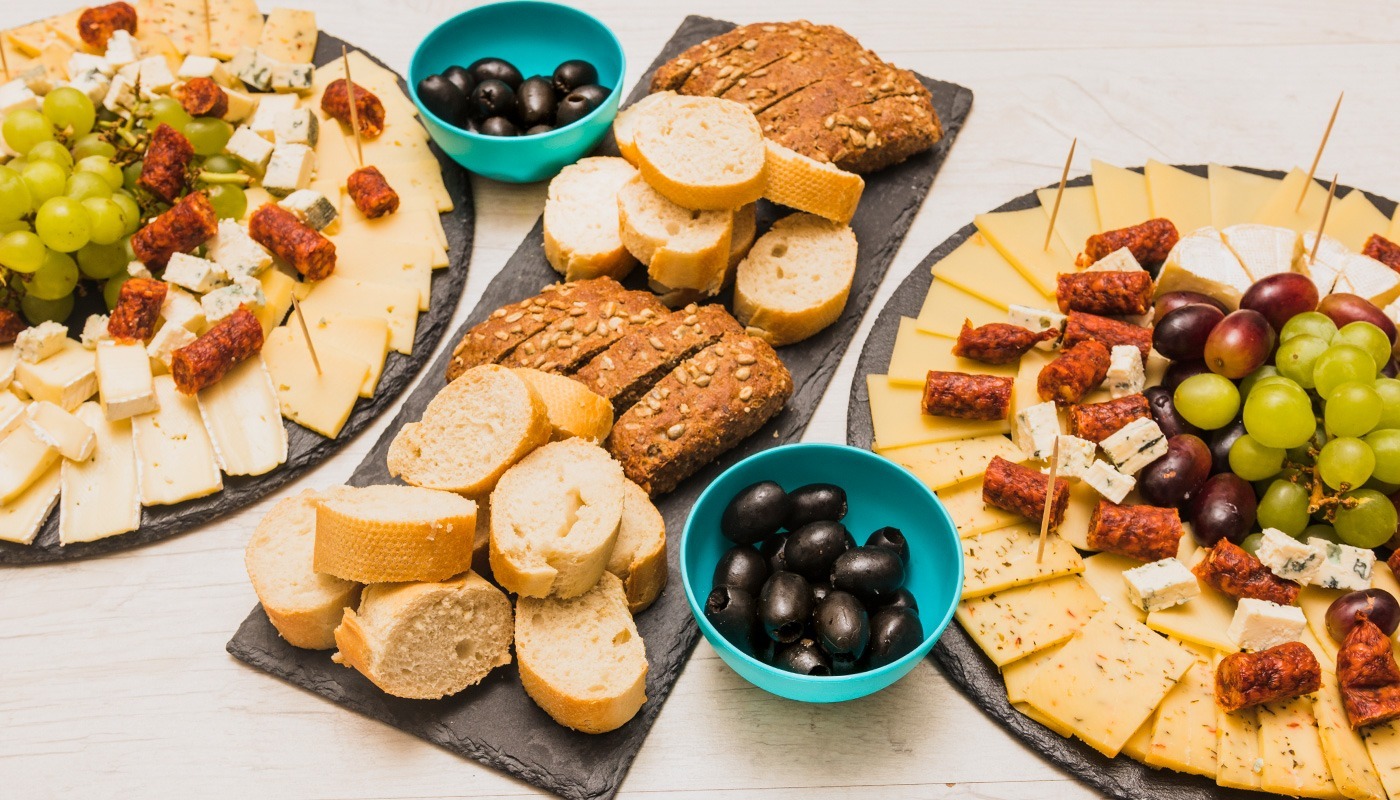 Appetizers and sides selection with cheese platter, bread, olives, grapes and charcuterie at Roatan Provision.
