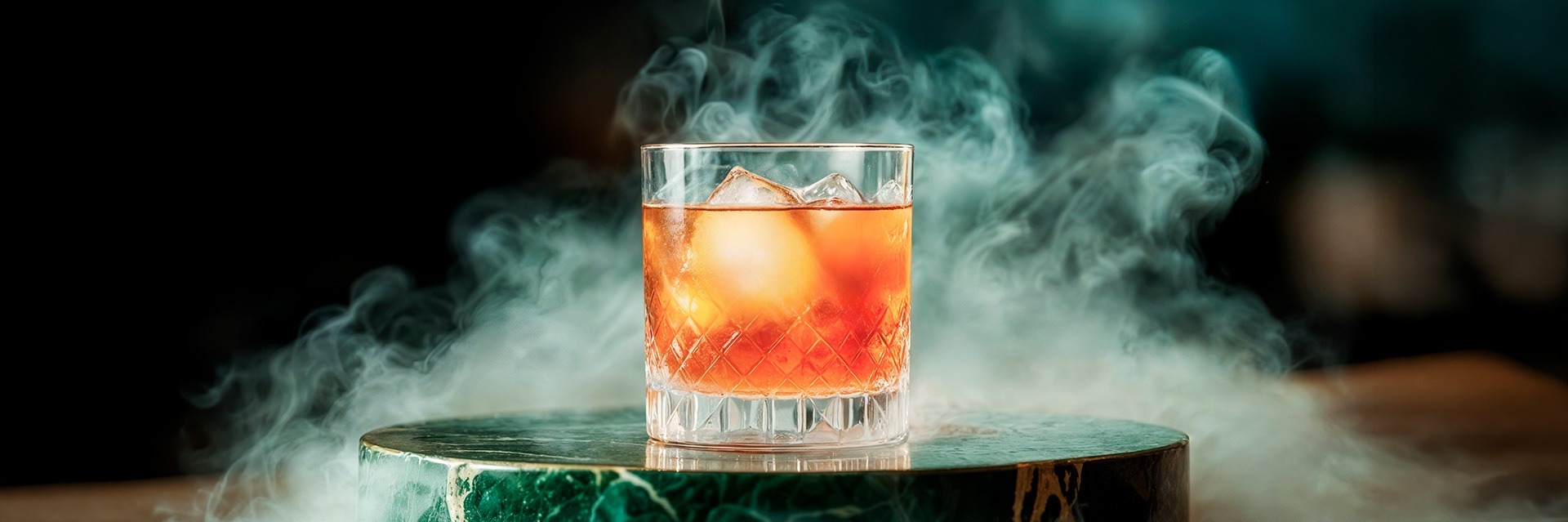 Cóctel premium de whisky con hielo y presentación ahumada, de Roatan Provision.
